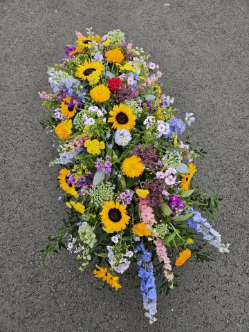 Casket spray - bright mix of colours replicating herbacious borders - summer garden style casket spray - sunflowers - delphinium - liatrus - larkspur - allium - roses 