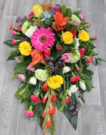 vibrant single ended spray  funeral tribute design - cerise gerbera and spray cars - yellow germini , solidaster and roses - orange gladioli - green carnation - purple limonium 