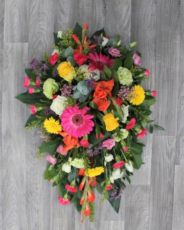 vibrant single ended spray  funeral tribute design - cerise gerbera and spray cars - yellow germini , solidaster and roses - orange gladioli - green carnation - purple limonium 