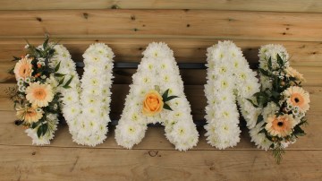 Nan funeral tribute based in white chrysanthemum with peach Germini and ivory sprays 